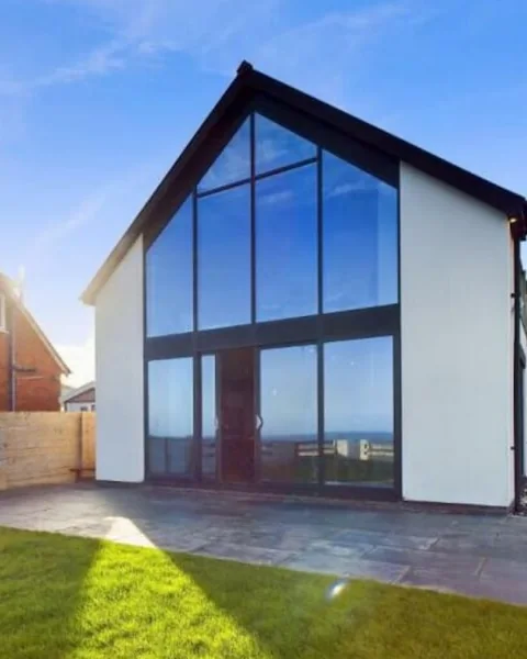 Castle Sunset on the Beach: the tall glass gable at the front of the house, in evening light