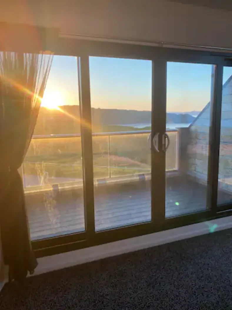 The sun going down over Cayton Bay through the upstairs balcony doors
